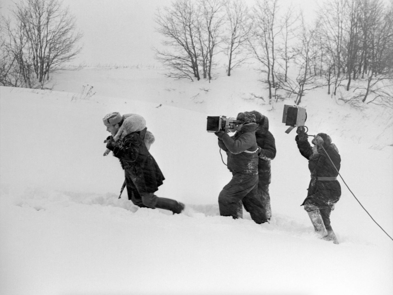 Een filmploeg met camera en geluid, tot de knieën in de sneeuw
